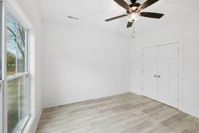 unfurnished bedroom featuring ceiling fan, a closet, and light hardwood / wood-style flooring