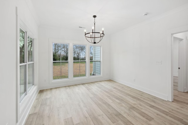 unfurnished dining area with ornamental molding, light hardwood / wood-style flooring, and an inviting chandelier