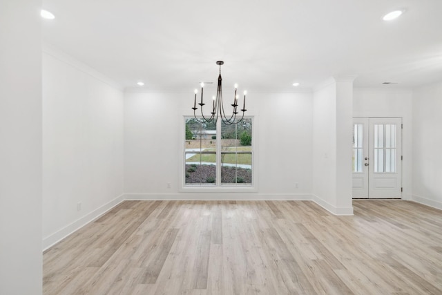 unfurnished dining area with a chandelier, crown molding, and light hardwood / wood-style floors