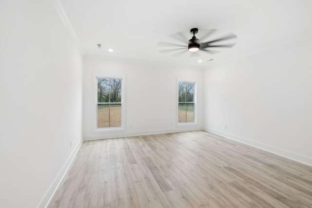 empty room featuring light hardwood / wood-style floors, a wealth of natural light, ornamental molding, and ceiling fan