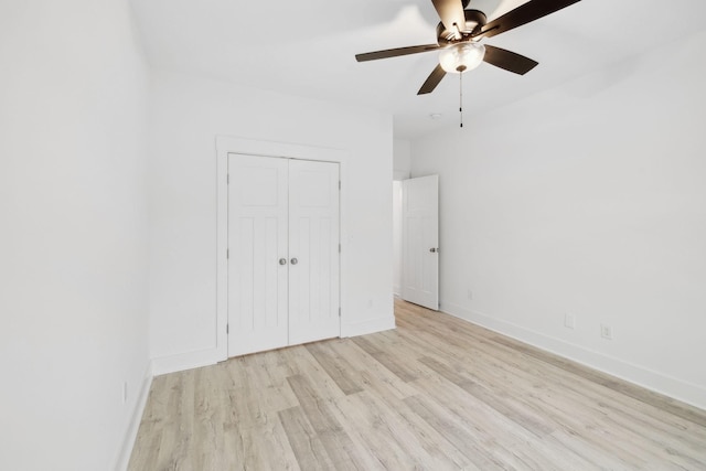 unfurnished bedroom with ceiling fan, light wood-type flooring, and a closet