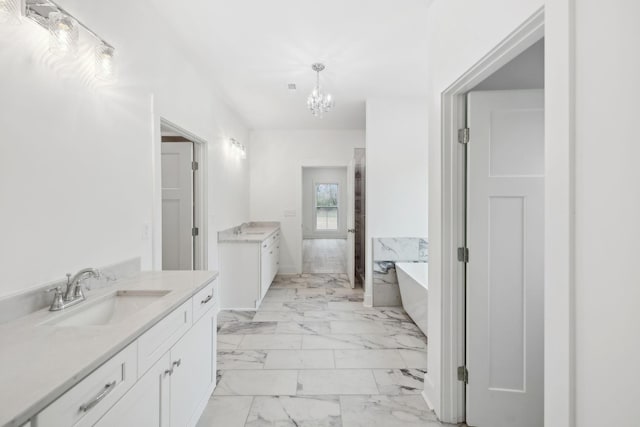 bathroom featuring a tub, vanity, and a chandelier