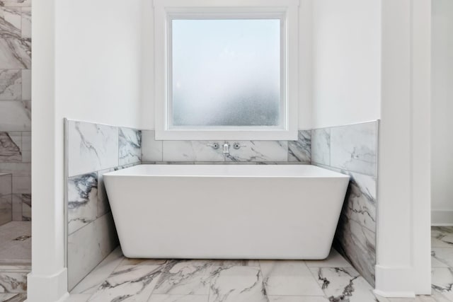 bathroom with a bathtub and tile walls