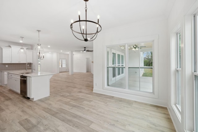 kitchen featuring white cabinetry, sink, tasteful backsplash, light hardwood / wood-style flooring, and pendant lighting