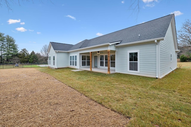 rear view of house featuring ceiling fan, a yard, and a patio