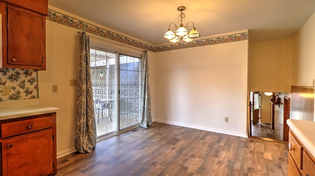 unfurnished dining area with hardwood / wood-style floors and a notable chandelier