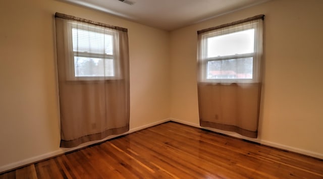 empty room featuring hardwood / wood-style flooring and a healthy amount of sunlight