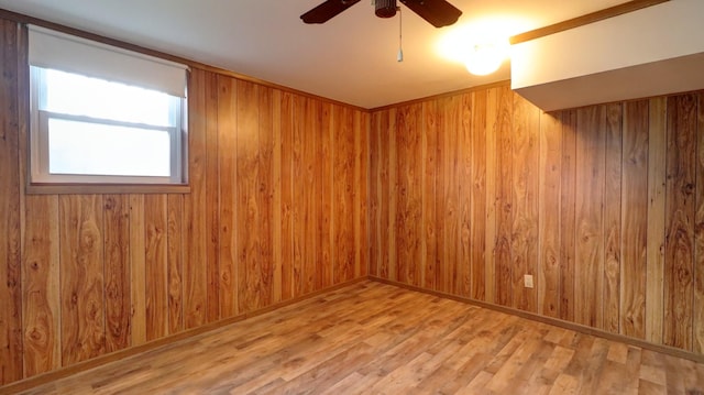 spare room with wood walls, hardwood / wood-style floors, and ceiling fan