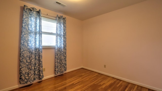 spare room featuring wood-type flooring