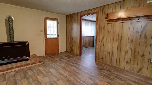 entryway featuring hardwood / wood-style floors, a healthy amount of sunlight, a textured ceiling, and wooden walls