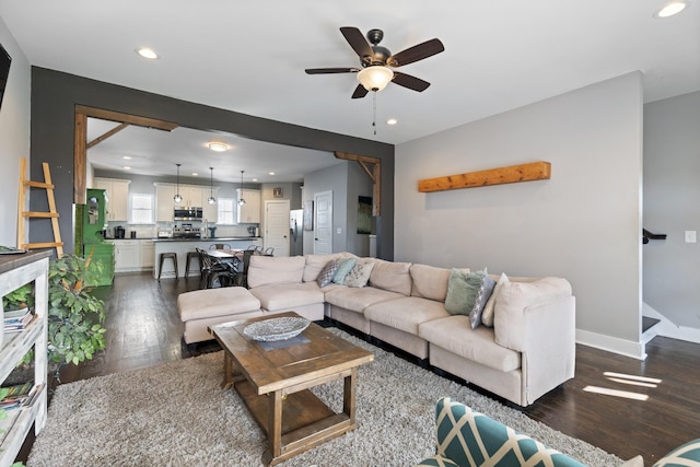 living room featuring ceiling fan and dark hardwood / wood-style floors