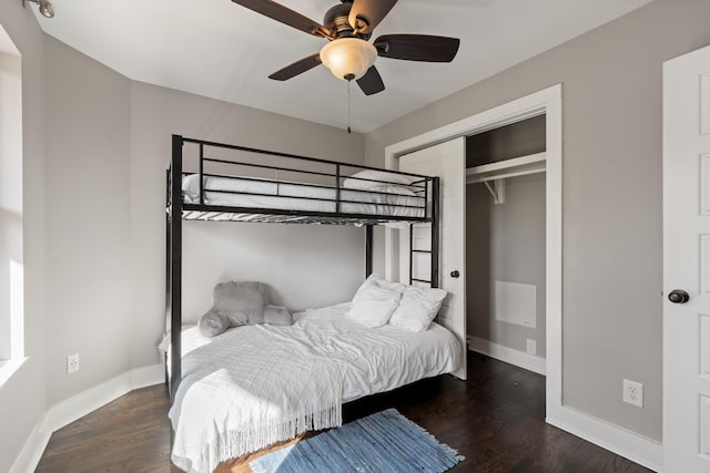 bedroom with a closet, dark hardwood / wood-style floors, and ceiling fan