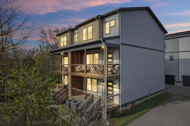 back house at dusk featuring a balcony