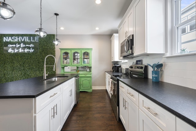 kitchen featuring sink, stainless steel appliances, dark hardwood / wood-style flooring, decorative light fixtures, and white cabinets