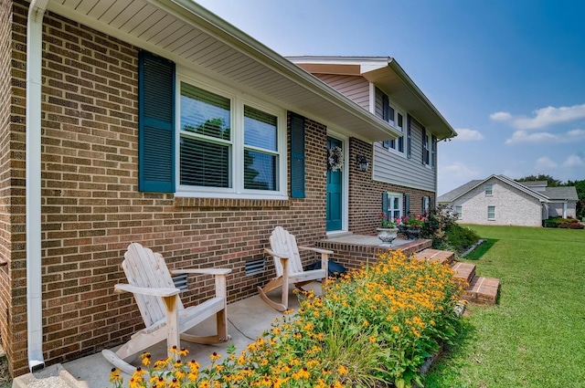 view of exterior entry featuring a yard