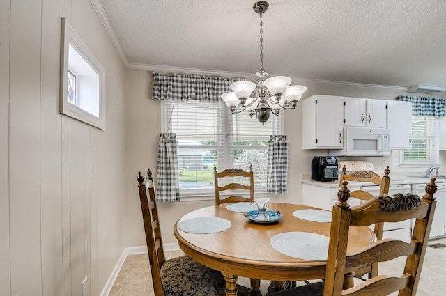 dining area featuring light tile patterned flooring, ornamental molding, a textured ceiling, and a chandelier