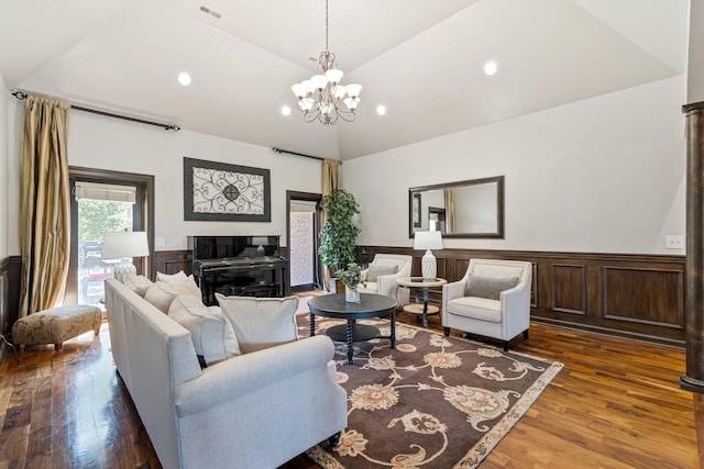 living room with dark hardwood / wood-style flooring, lofted ceiling, and an inviting chandelier