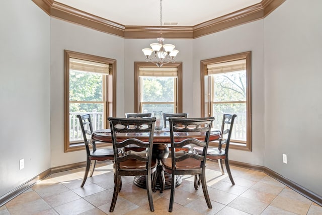 tiled dining space featuring plenty of natural light, ornamental molding, and an inviting chandelier