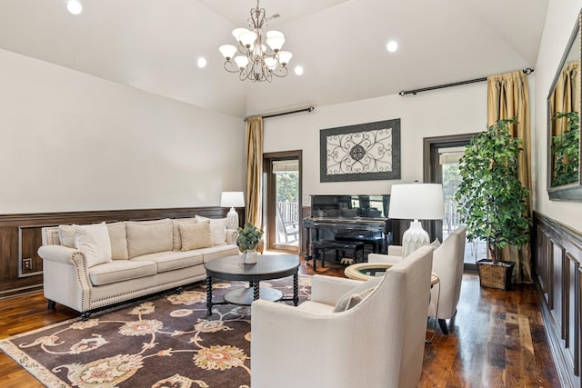 living room featuring dark hardwood / wood-style flooring, lofted ceiling, and an inviting chandelier