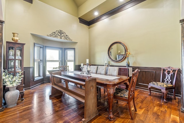 dining area featuring dark hardwood / wood-style flooring, a towering ceiling, and crown molding