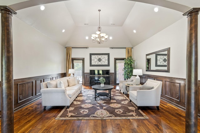 living room featuring a chandelier, decorative columns, vaulted ceiling, and dark wood-type flooring