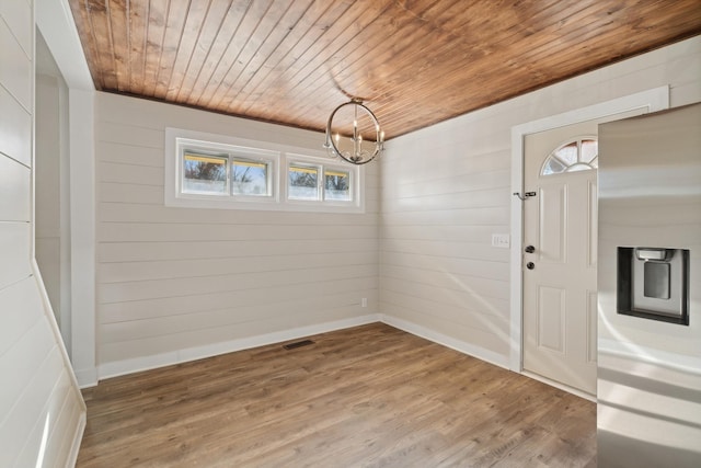 unfurnished dining area with a notable chandelier, a healthy amount of sunlight, wood-type flooring, and wood ceiling