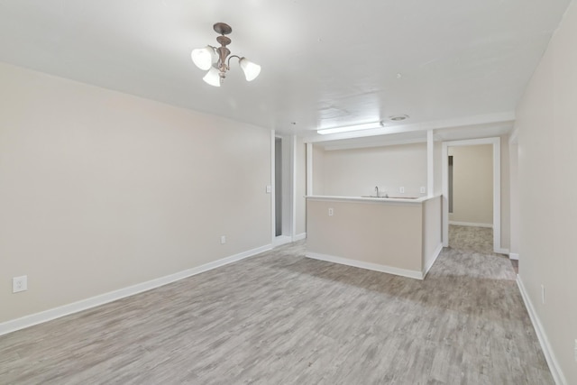 unfurnished living room featuring light hardwood / wood-style floors and a notable chandelier