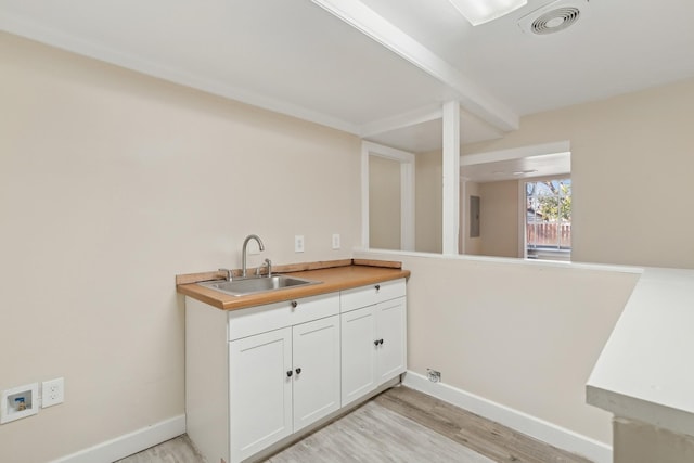 washroom with washer hookup, light hardwood / wood-style flooring, and sink