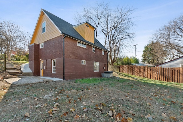 rear view of property featuring central AC unit and a patio area