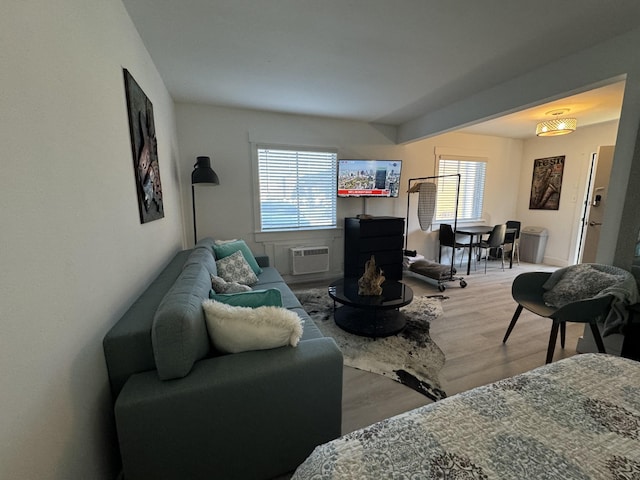 living room featuring a wall mounted air conditioner and light hardwood / wood-style floors