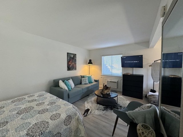 bedroom featuring a wall unit AC and light wood-type flooring