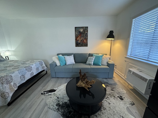 bedroom featuring a wall mounted AC and light hardwood / wood-style flooring