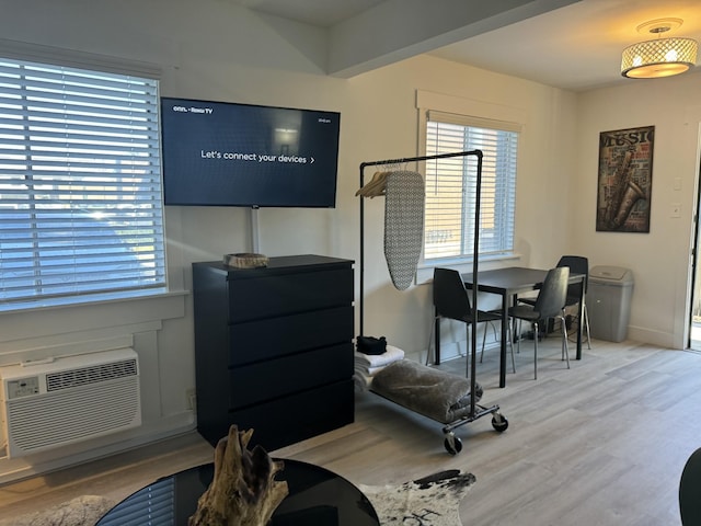 home office with a wall unit AC and hardwood / wood-style flooring