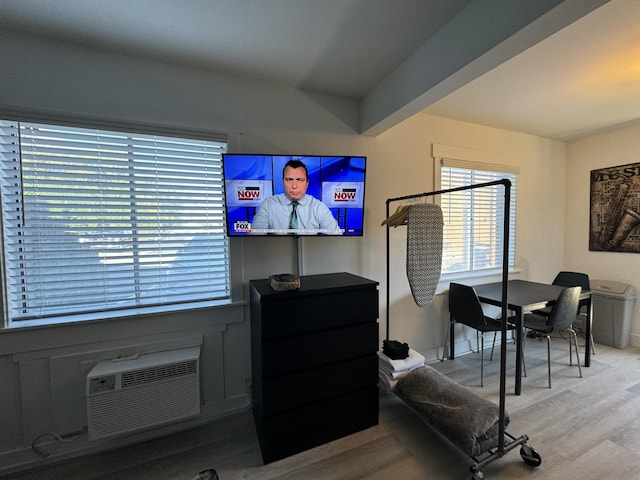 living room with light hardwood / wood-style floors and an AC wall unit