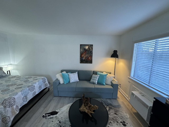 bedroom featuring hardwood / wood-style floors and a wall mounted AC