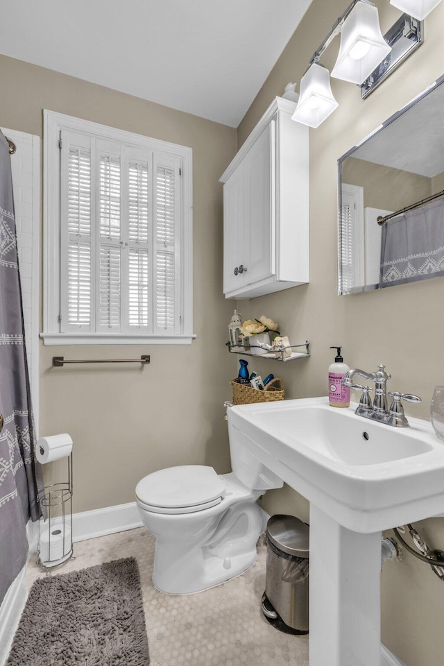 bathroom with tile patterned floors, curtained shower, toilet, and sink