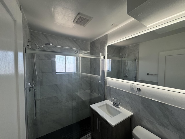 bathroom featuring tile walls, vanity, decorative backsplash, toilet, and walk in shower