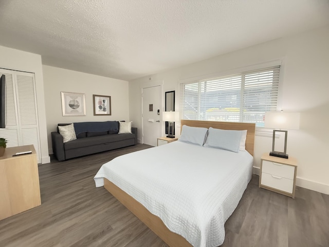 bedroom with dark wood-type flooring, a closet, and a textured ceiling