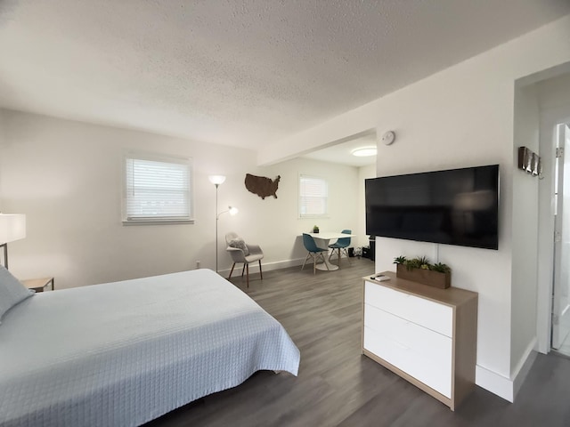 bedroom featuring dark wood-type flooring and a textured ceiling