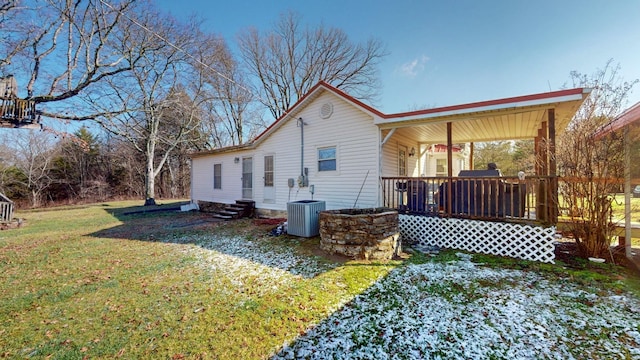 rear view of house with a porch, a yard, and central air condition unit