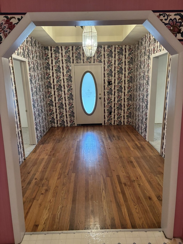 additional living space featuring wood-type flooring and an inviting chandelier