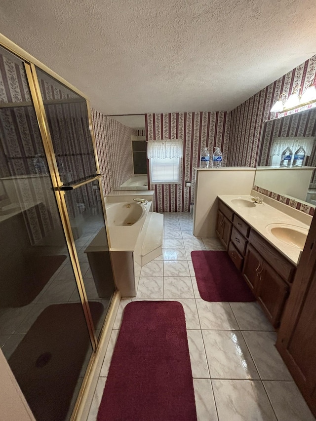 bathroom with vanity, independent shower and bath, and a textured ceiling