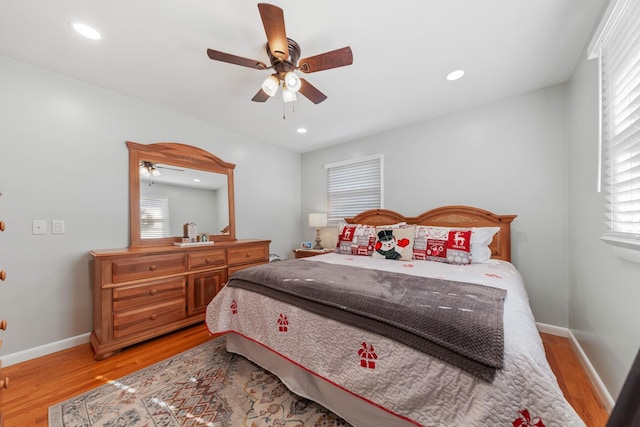 bedroom featuring ceiling fan, multiple windows, and light wood-type flooring