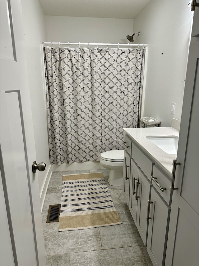 bathroom featuring curtained shower, vanity, and toilet