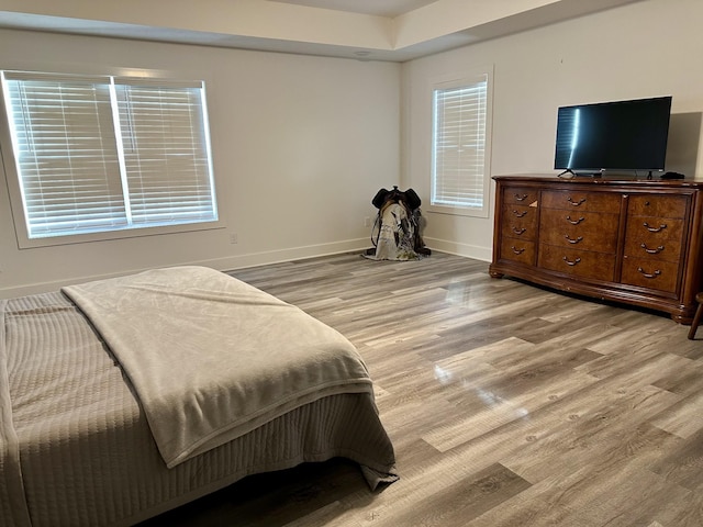 bedroom featuring multiple windows and light hardwood / wood-style flooring