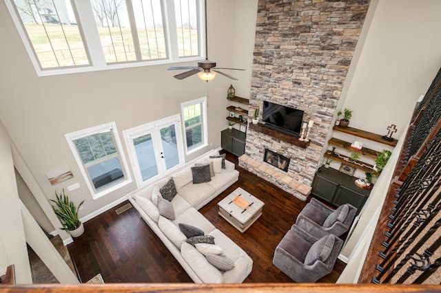 living room featuring a fireplace, hardwood / wood-style floors, and a high ceiling