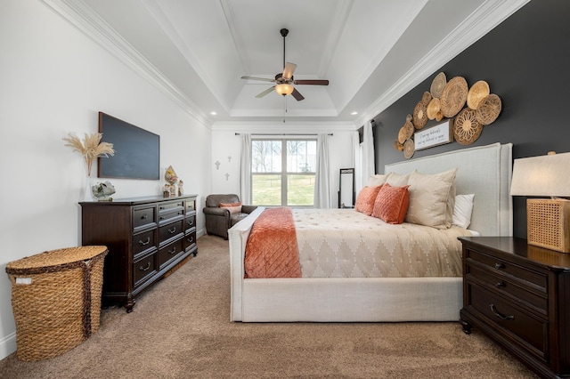 bedroom featuring a tray ceiling, light carpet, crown molding, and ceiling fan