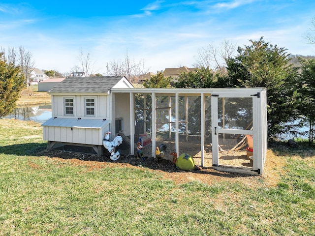 rear view of house with an outdoor structure and a lawn