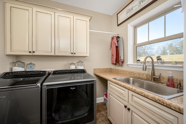 washroom with cabinets, separate washer and dryer, dark tile patterned floors, and sink