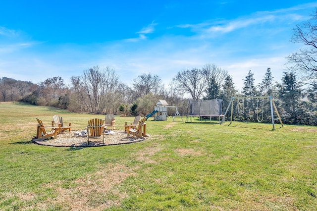 view of yard featuring a fire pit, a trampoline, and a playground